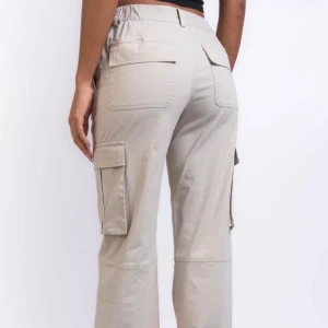 Madlady cargo byxor - Säljer ett par snygga beige cargobyxor från Madlady. De har praktiska fickor på sidorna och är perfekta för en avslappnad stil. Byxorna är midwaist och passar till både vardag och äventyr. Perfekta för höst och vår! Knappt använda och är som ny. Hör gärna av dig vid intresse!