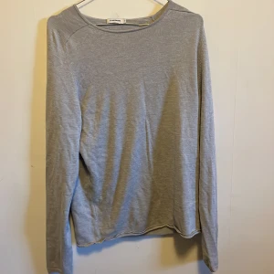 Grå långärmad tröja från J.Lindeberg - Säljer en stilren grå långärmad tröja från J.Lindeberg i storlek M. Perfekt för både vardag och lite finare tillfällen. Tröjan är i bra skick och har en klassisk passform. Skön och enkel att matcha med olika outfits.