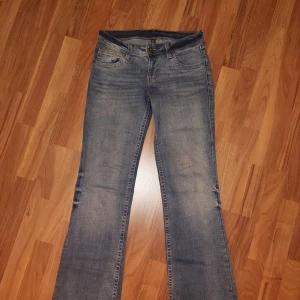 Blå bootcut jeans - Säljer ett par snygga bootcut jeans med coola fickor med knapp. De är i nyskick, endast testade!