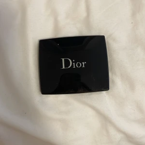 Dior rouge blush - Säljer ett elegant blush från Dior i en lyxig svart kompakt med spegel.spegeln har gått lite sönder. Perfekt för att ge kinderna lite extra glöd. Kompakt och lätt att ta med i väskan för touch-ups under dagen.
