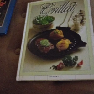 Grillat - En inspirerande kokbok från Richters med fokus på grillning. Boken har ett omslag med en bild av grillad mat, inklusive kött och grönsaker, samt grillredskap. Perfekt för sommarens grillfester och att utforska nya recept.