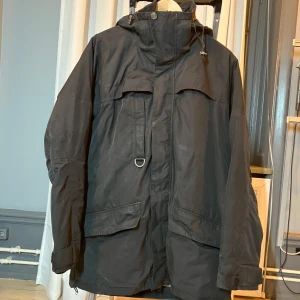 Svart jacka från Snoot - Snygg svart fodrad jacka från lyxmärket Snoot med hög krage, huva och praktiska fickor. Jackan har en stilren design med dragkedja och knappar framtill. Perfekt för kyligare dagar. Den som känner till Snott vet att dessa jackor är av högsta kvalitet å kommer hålla under många vintrar framåt! Nypris uppskattat till 9000–12000 SEK.  Finns på Södermalm för snabb upphämtning.  Kontakta mig gärna om du är intresserad eller har frågor!  Swish går bra! Pris kan alltid diskuteras vid snabb affär!