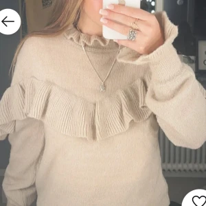 Beige stickad tröja med volang - Fin tröja något stor i storleken 
