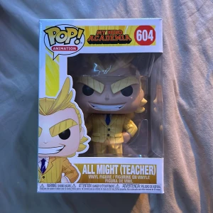 Funko Pop! Animation All Might (Teacher) från My Hero Academia - Säljer en Funko Pop! figur av All Might (Teacher) från My Hero Academia. Figuren är nummer 604 i serien och kommer i en snygg gul kostym med blå slips. Perfekt för samlare av anime-figurer eller fans av serien. 