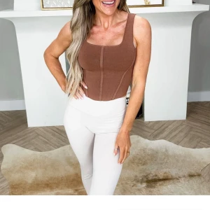 Brun korsettopp size Medium, ny med lappar! - Snygg brun korsettopp i bandagematerial. 77%viscose. Helt my med lappar. Skapar en väldigt snygg figur och kvadratisk urringning. okänt märke. Nypris $40 ( motsvarande 400kr)