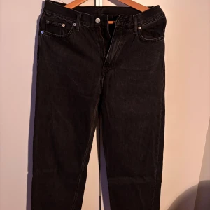 Svarta galaxy jeans från Weekday - Snygga svarta jeans från Weekday, Galaxy modellen. De har en rak/loose passform. Den mörkgråa färgen gör de perfekta för en stilren look. Knappt använda. Storlek 27/30.