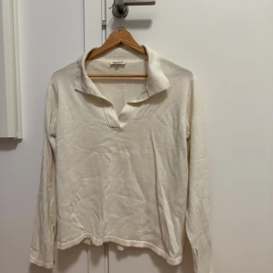 Vit långärmad tröja från Djerf Avenue - Säljer en stilren vit långärmad tröja från Djerf Avenue. Tröjan har en klassisk krage och är tillverkad i ett mjukt material som ger en bekväm passform. Perfekt för en avslappnad look.