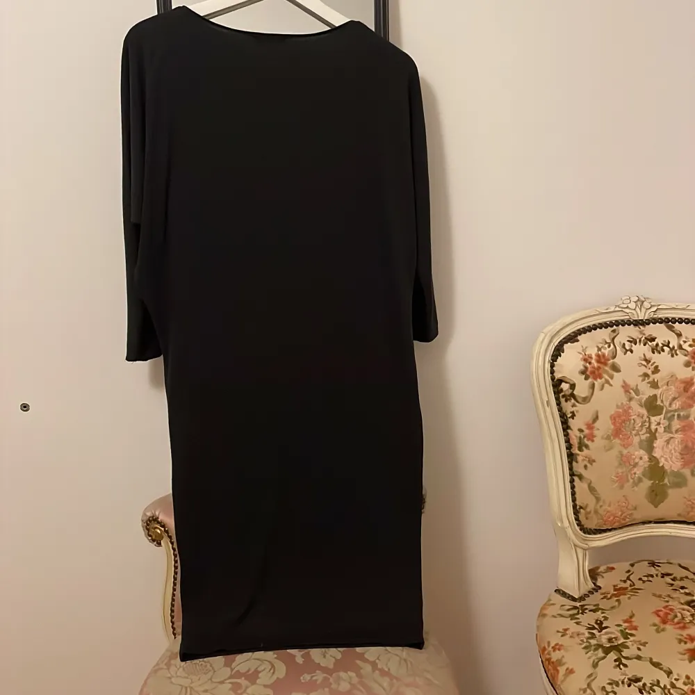 Elegant dark grey klänning från Massimo Dutti i en stilren design. Klänningen har trekvartsärmar och en klassisk passform som passar perfekt för både vardag och festligare tillfällen. Tillverkad i ett mjukt och bekvämt material.. Mekot.