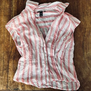 Rosa randig kortärmad skjorta - Rosa randig linne skjorta! Super fin och skön! Lite sliten på ena armen under armhålan (se bild 3) men inget som syns tydligt!