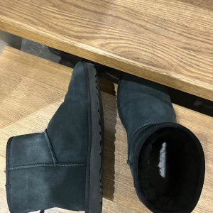 UGGS - Säljer ett par svarta UGG boots i mocka. De är fodrade för extra värme och komfort. Perfekta för kyliga dagar. Box tillkommer