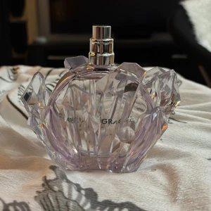 R.E.M Parfym från Ariana Grande - Helt ny.Säljer en elegant parfym från Ariana Grande. Flaskan har en unik kristallformad design med en lila ton och silverfärgad spraypump. Perfekt för den som älskar en lyxig och iögonfallande flaska.Saknar locket dock.