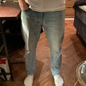 Ljusblå jeans - Säljer ett par ljusblåa jeans i ganska bra skick! Har använts men är omhändertagna och har inga större slitage. Storleken på jeansen är inte synlig men modellen på bilden har storlek 31/30. Perfekta för både vardag och mer avslappnade tillfällen. Skriv om du är intresserad eller andra frågor!