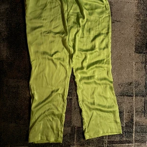 Limegröna byxor - Snygga limegröna byxor i ett lätt och luftigt material. Perfekta för en färgglad och bekväm stil. De har en avslappnad passform och är idealiska för varma dagar.