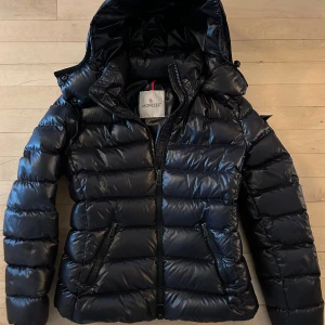 Svart Moncler dunjacka, modell Bady strlk 0 (xs) - Tidlös och superfin Moncler dunjacka. Modell bady, färg svart. Passar en tjej som är ca 158-164 cm.  Perfekt för kyliga dagar.