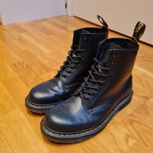Dr Martens storlek 45 - Säljer ett par klassiska svarta Dr. Martens boots. Skorna har en slitstark sula och är tillverkade i skinn. Mycker sparsamt använda, men notera små tecken på användning där lädret vikts vid tårna.