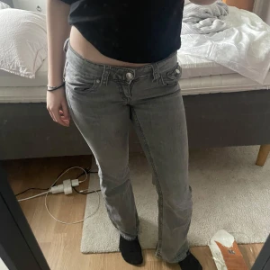 Grå jeans med låg midja - Säljer ett par grå jeans med låg midja och bootcut passform. Dom är ifrån Gina Young och är i storlek 146. Jag har spretat upp byxorna längst ner. Dom är för små för mig, de är därför jag säljer dom. Snygga fickor och väldigt Low waist.