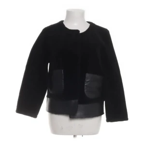 Svart jacka från Bool - Snygg svart jacka med en stilren design. Jackan har långa ärmar och detaljer i skinn som ger en lyxig känsla. Perfekt för att höja din outfit till nästa nivå.