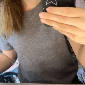 Grå t-shirt - Säljer en stilren grå t-shirt med rund hals och korta ärmar. Perfekt för en avslappnad look.