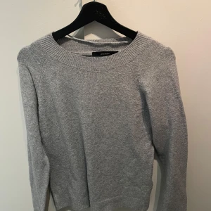 Grå stickad tröja från Vero Moda - Säljer en stilren grå stickad tröja från Vero Moda. Tröjan har en klassisk rund halsringning och långa ärmar, perfekt för kyligare dagar. Enkel och tidlös design som passar till det mesta.