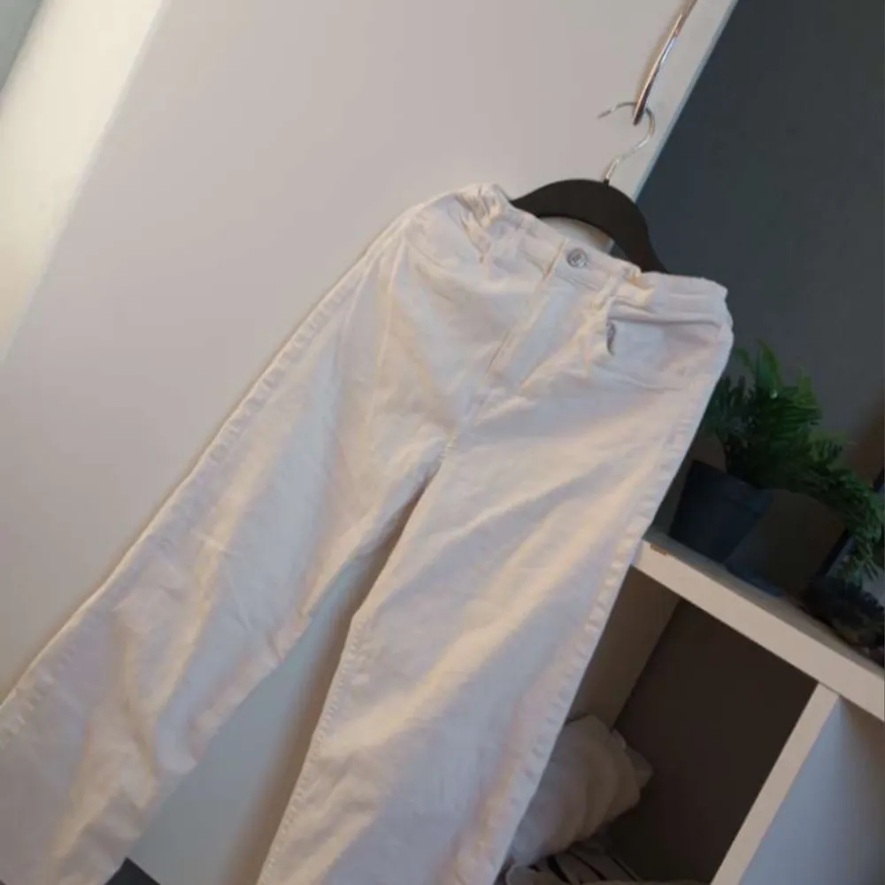 Snygga vita byxor med hög midja och rak passform. Perfekta för en stilren look. Byxorna har fickor bÄde fram och bak.. Farkut & Housut.