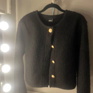 Svart kofta med guldknappar - Svart kofta från Gina Tricot. Knappast använd därav väldigt bra skick!