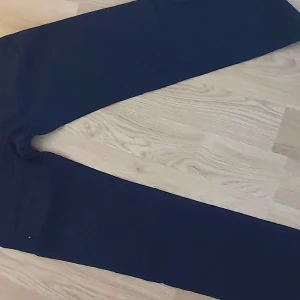 Mörkblå linne byxor från Lindex - Snygga mörkblå linnebyxor från Lindex med knappar och snörning i midjan. Perfekta för en stilren look. Byxorna har en rak passform och är tillverkade i ett bekvämt material.