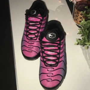 Nike sneakers i rosa och svart - Snygga Nike sneakers i en cool rosa och svart färgkombination. Skorna har ett unikt mönster och klassisk snörning. Perfekta för att sticka ut i mängden. Är 100% äkta