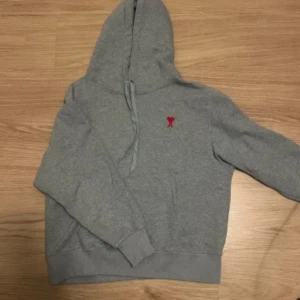 Ami Paris hoodie - Säljer en stilren grå hoodie från ami paris. Perfekt för både vardag och chill. Passar till allt och är superbekväm! Ny pris runt 3199kr mitt pris 1899kr vid funderingar hör gärna av er!