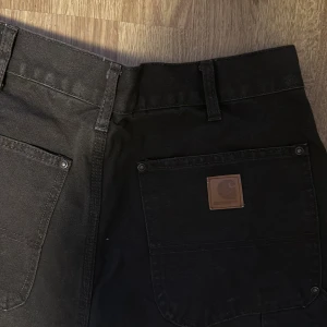 Bruna carpenter byxor från Carhartt - Säljer ett par bruna arbetsbyxor från Carhartt i loose fit. Byxorna är tillverkade i 100% bomull och har flera praktiska fickor. Perfekta för arbete eller fritid. Köpta på second hand humana, men i mycket bra skick.