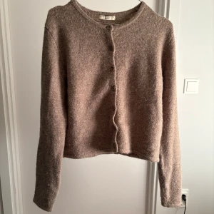 Beige/brun  kofta från Gina Tricot - Mysig beige/brun kofta från Gina Tricot i premiumkvalitet. Den har långa ärmar och knappar framtill. Nästan aldrig använd! Köptes runt 500kr . Säljer för 200kr❤️ storlek M . Skriv vid intresse eller funderingar.