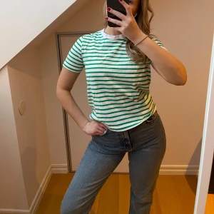 Grön- och vitrandig t-shirt från Zara - Snygg grön- och vitrandig t-shirt med korta ärmar från Zara. I storlek M, men skulle säga att den sitter som en S. Super fin att matcha med ett par linne byxor i vår eller ett par jeans shorts i sommar💚 använd 2 gånger