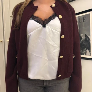 Vinröd kofta med guldknappar - Snygg vinröd kofta med guldknappar framtill. Helt ny med prislapp kvar.