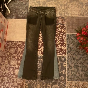 Lowaist bootcut jeans lee  - Snygga grå/ blåa bootcut jeans från Lee med en cool tvättad look. De har tyvärr ett hål på vänstra sidan längs sömmen, men det borde gå lätt att fixa!✨