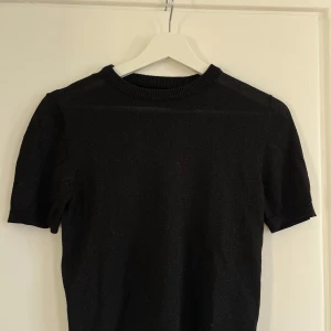 Svart kortärmad tröja från ONLY - Säljer en stilren svart tröja från ONLY. Den är svart med lite glitter på. Snygg lite genomskinlig och endast använd 1 gång. 