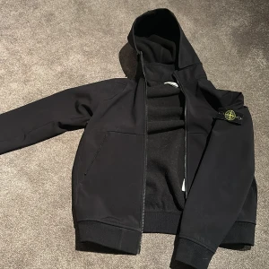 Svart luvjacka från Stone Island - Säljer en svart stone island jacka/cardigan. Obs junior strl. Junior M/L