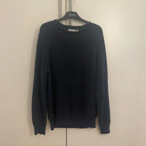 Mörkblå stickad tröja från weekday - Säljer en stilren mörkblå stickad tröja. Tröjan har en klassisk rund halsringning och långa ärmar, perfekt för kyligare dagar. Den är mjuk och bekväm, idealisk för både vardag och mer avslappnade tillfällen. Är i storlek S men lite oversized.