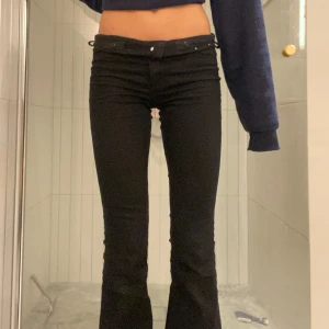 Svarta bootcut jeans - Snygga svarta bootcut jeans med medelhög midja!  Perfekta för en stilren look. De har en knapp och dragkedja framtill.