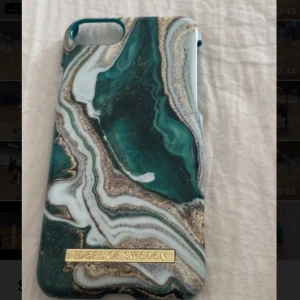 Mobilskal från Ideal of Sweden - Snyggt mobilskal från Ideal of Sweden med ett marmorliknande mönster i grönt, vitt och guld. Perfekt för att ge din telefon en stilren look. Skalet har en elegant design med en guldig logotypdetalj.