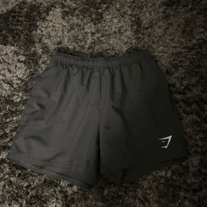 Gråa träningsshorts från Gymshark - Ett par gråa träningsshorts från Gymshark i herrstorlek XS. I ett bra skick. Hör av dig vid funderingar.