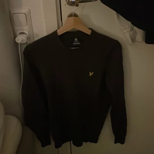 Mörk grön från Lyle & Scott - Säljer en snygg mörk grön tröja från Lyle & Scott med deras ikoniska logga på bröstet. Tröjan har långa ärmar och är perfekt för kyligare dagar. Den är tillverkad i ett mjukt material som ger en bekväm passform.