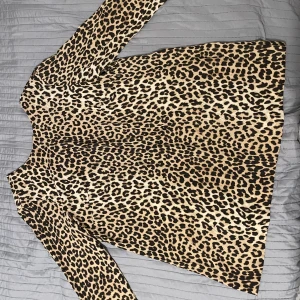 Leopardmönstrad klänning från H&M - Säljer en trendig leopardmönstrad klänning från H&M. Den har en klassisk passform med långa ärmar och är perfekt för att ge din outfit en djärv touch. 🐆