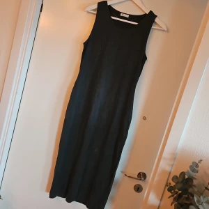 Grå ärmlös klänning - Snygg grå ärmlös klänning. Klänningen har en enkel och stilren design med en knälång längd som passar perfekt för olika tillfällen. Tillverkad i ett mjukt och bekvämt material.