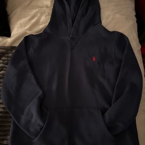 Mörkblå hoodie från Ralph Lauren - Säljer en stilren mörkblå hoodie från Ralph Lauren med det klassiska röda logotypen på bröstet. Size XL men passar S då XL är en barn storlek.