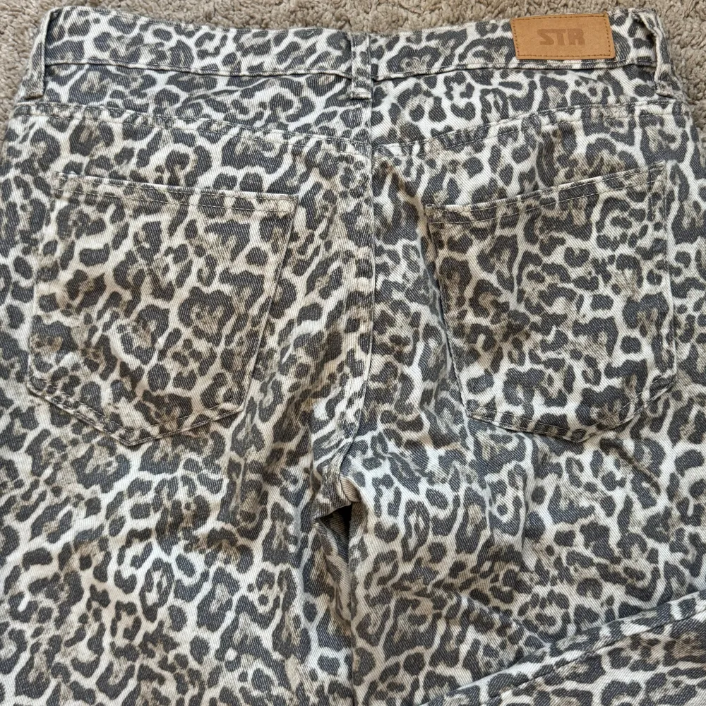 Snygga leopardmönstrade byxor från Stradivarius i storlek 36. Byxorna har en klassisk femficksdesign och är perfekta för att ge din outfit en djärv touch. Tillverkade i Turkiet med en bekväm passform.. Farkut & Housut.