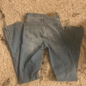 Blå jeans från 157 - Snygga blå jeans från 157 med klassisk femficksdesign och knappgylf. Perfekta för en avslappnad stil. De har en rak passform och är tillverkade i slitstarkt denim. High waist och lite utsvängda 