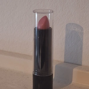 Rosa läppstift i svart hylsa - Snyggt rosa läppstift i en elegant svart hylsa med genomskinligt lock. Aldrig använt💕