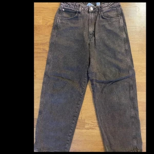 Bruna baggy jeans från H&M - Säljer ett par grå baggy jeans från H&M i storlek 14Y. De har en avslappnad passform och är perfekta för en casual look. Jeansen har en klassisk design med fickor både fram och bak. Perfekta för höst och vår!