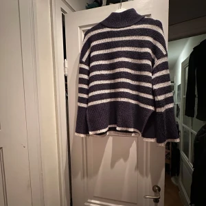 Randig stickad tröja - Mysig stickad tröja i marinblått och vitt med högre krage. Perfekt för kyliga dagar. 