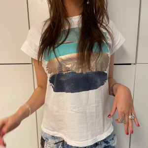 VIT T-SHIRT MED TRYCK - Skitsnygg vit T-shirt med coolt tryck!! Tjejen på bilden är 175 cm lång och t-shirten är i storlek S. Hör av er vid frågor!!