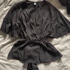 Fin svart blus - Jättefin blus med band att knyta där bak endast använd en gång så i princip helt ny.
